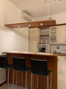 a kitchen with a bar with four chairs at it at Trionfo your home in Trieste business and holiday stays in Trieste