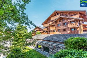 una vista exterior de un edificio de una cabaña de madera en Résidence Pierre & Vacances Premium Les Fermes Du Soleil, en Les Carroz d'Araches