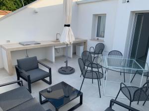 een patio met stoelen en een glazen tafel en een tafel en stoelen bij Casa sulla spiaggia Indipendente in Alcamo