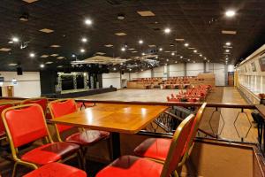 a room with a table and chairs and a stage at Pontins - Prestatyn Sands Holiday Park in Prestatyn