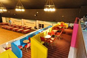 a dining room with colorful tables and chairs at Pontins - Prestatyn Sands Holiday Park in Prestatyn