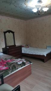 two beds in a room with a ceiling at Гостевой дом на Коллективной in Kabardinka