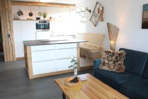 a kitchen and living room with a couch and a table at Hochwertige Sonneninsel mit Aussicht in Tettnang