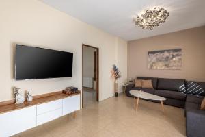 a living room with a couch and a flat screen tv at Aileen Villa in Koskinou +41 photos