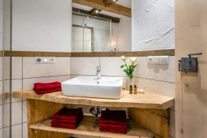 a bathroom with a white sink and red towels at Naderbauer-Hof in Marquartstein