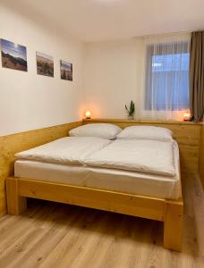 sypialnia z łóżkiem z drewnianą ramą w obiekcie Apartmány Jasná, Biela Púť w Demianowskiej Dolinie