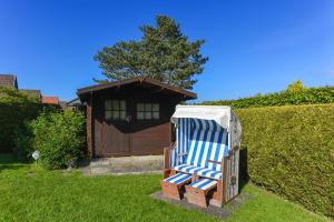 une chaise bleue et blanche assise dans une cour dans l'établissement Ferienhaus Boje 13, à Neuharlingersiel