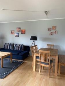 een woonkamer met een blauwe bank en een tafel bij Jacobihof Haus 3 Wohnung 01 in Dahme