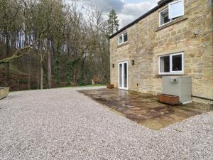 a stone house with a gravel driveway in front of it at Paradise Cottage in Harrogate