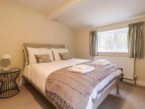 a bedroom with a bed and a window at Paradise Cottage in Harrogate