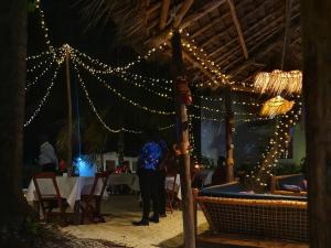 a person standing in front of a table with lights at Blue Palm Zanzibar in Bwejuu +125 photos