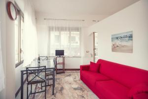 a living room with a red couch and a table at Sanremo City Center II by Wonderful Italy in Sanremo