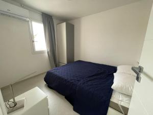 una camera con un letto blu e una finestra di Casa sulla spiaggia Indipendente ad Alcamo