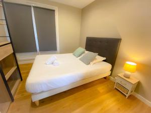 een kleine slaapkamer met een wit bed en een raam bij Appartement renove et moderne L'Eustache in Calais