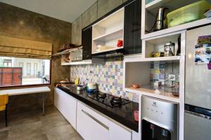 una cucina con mobili bianchi e un forno a piano cottura di Villa Cleopatra Bali a Sanur