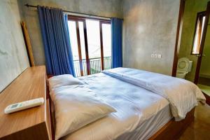 un letto grande in una stanza con una finestra di Villa Cleopatra Bali a Sanur
