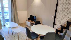 ein Wohnzimmer mit einem Tisch und Stühlen sowie einem TV in der Unterkunft Hypercentre lamartine 505 in Nizza