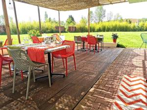 un patio con sillas y mesas rojas y una sombrilla en Hôtel Restaurant Evan, en Lempdes sur Allagnon