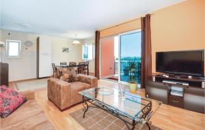 uma sala de estar com uma televisão e uma mesa de vidro em 2 Bedroom Nice Apartment In Split em Split