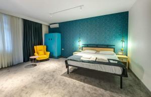 a bedroom with a bed and a yellow chair at Betlemi Hotel in Tbilisi City