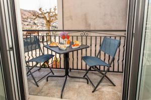 een tafel en stoelen op een balkon met eten erop bij Casa Imperati in Pianillo