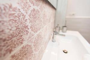 een badkamer met een witte wastafel en een roze muur bij Casa Imperati in Pianillo