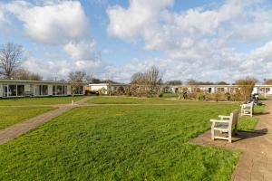 a park with two chairs sitting in the grass at Pakefield Holiday Village - Adults Only in Lowestoft