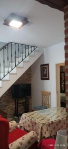 a living room with a table and a staircase at Casa Monte Los Peñasquitos in Cazalla de la Sierra