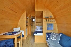 Habitación pequeña con cama y sofá en una cabaña en Hausboot Captain Hook, en Gager