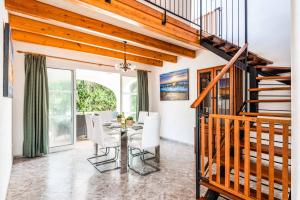 Un comedor con una mesa y sillas blancas. en Villa Karoline, en Cala en Forcat