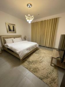 1 dormitorio con 1 cama grande y TV en villa in king Abdullah economic city luxury feel W private pool en King Abdullah Economic City