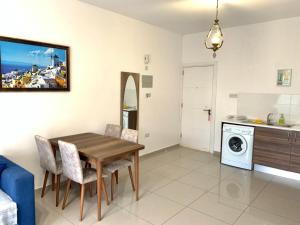 eine Küche und ein Esszimmer mit einem Holztisch und Stühlen in der Unterkunft Beautiful & Quiet Two-Bedroom Apartment with Private Garden Lukomorye C1 in Kyrenia + 14 Fotos