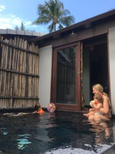 a couple of women sitting in a swimming pool at Jasmine & Tea House in Mae Nam