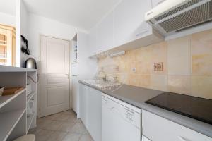 cocina con armarios blancos y encimera en AS14627 - P3 au coeur du Centre Ville avec parking privé, en Le Grau-du-Roi