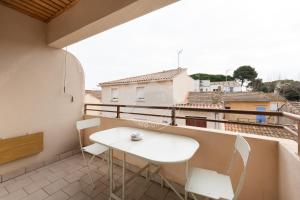 a white table and chairs on a balcony with a view at AS14627 - P3 au coeur du Centre Ville avec parking privé in Le Grau-du-Roi