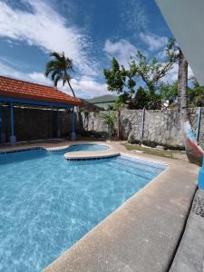 una piscina en un patio con una valla y árboles en Metro Park Hotel - Cebu City, en Cebú