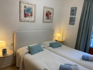 duas camas num pequeno quarto com duas lâmpadas em Apartamento Mirador De La Darsena em Port Saplaya
