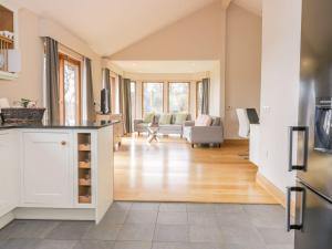 a kitchen with white cabinets and a living room at Whittadder Lodge in Chirnside