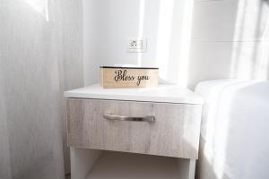 a small drawer with a box on top of it at White home in Timişoara