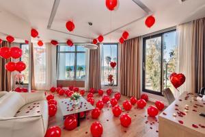 sala de estar con globos rojos en el suelo en Marina Premium Hotel en Vlorë