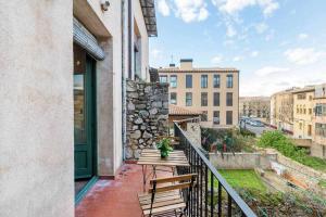 einen Balkon mit einem Holztisch und Stadtblick in der Unterkunft Sleep y Stay Arab Baths Ático Apartment in Girona