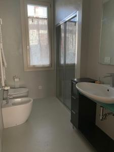 a bathroom with a sink and a tub and a toilet at Azapartments in Treviso