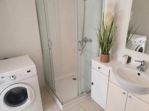 a bathroom with a washing machine and a shower at Le Cézanne - Climatisé avec grande terrasse in Gréoux-les-Bains