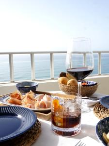 a table with a glass of wine and some food at FAY Victoria Beach in Rincón de la Victoria