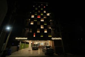 a building at night with cars parked in front of it at GRAND GANPAT in Vellore