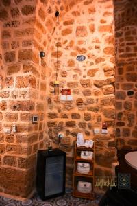 a room with a stone wall with a tv in it at Suleiman Pash in ‘Akko +35 photos