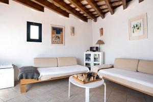 sala de estar con sofá y tablero de ajedrez sobre una mesa en Sunny Rustic Townhouse, en Vejer de la Frontera