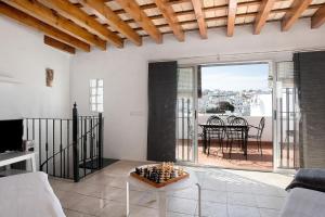 una sala de estar con un sofá y una mesa en Sunny Rustic Townhouse, en Vejer de la Frontera