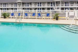 a pool in front of a hotel with blue chairs at Days Inn by Wyndham Madison in Madison