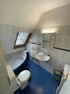 een badkamer met een bad, een toilet en een wastafel bij Othman Appartements Groß Buchholzer Straße 16a in Hannover
